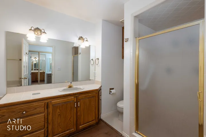 Full bath featuring vanity, a stall shower, and dark wood finished floors