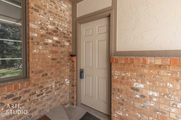 View of exterior entry featuring brick siding
