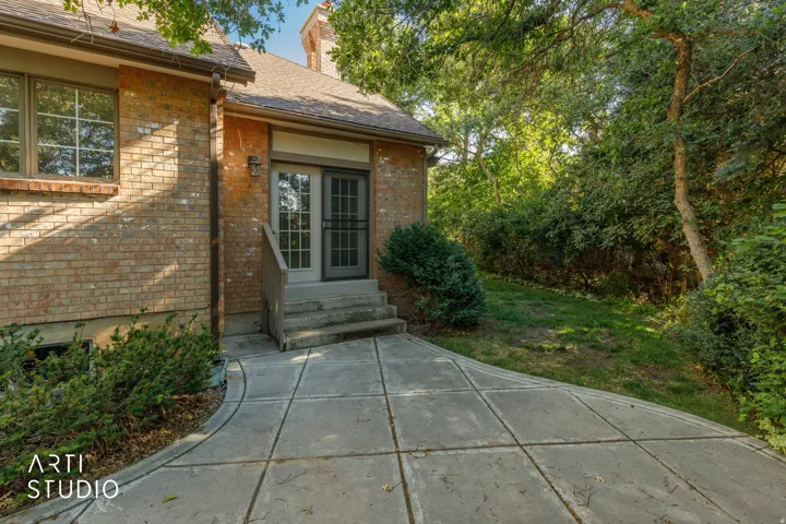 Brick exterior with a peaked roofline, offering an exterior entry with wood steps and French doors