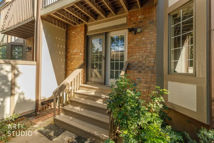 Brick exterior with a transom door, glass panel door, and exterior lighting fixture
