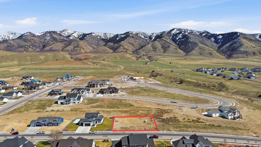 Aerial view of residential area featuring property parcel outlined and a mountain backdrop
