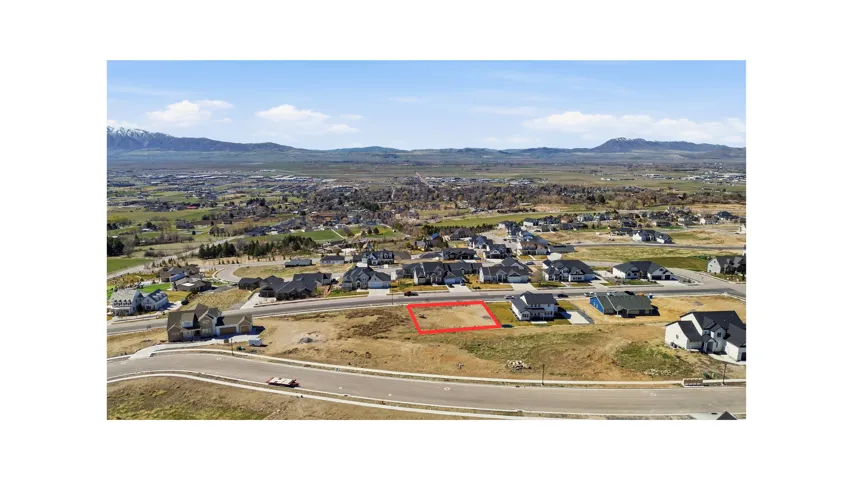Aerial view of residential area with property boundaries highlighted and a mountain backdrop