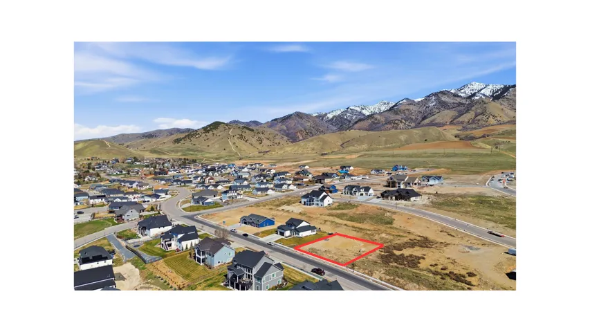 Aerial view of residential area with property boundaries highlighted and mountains