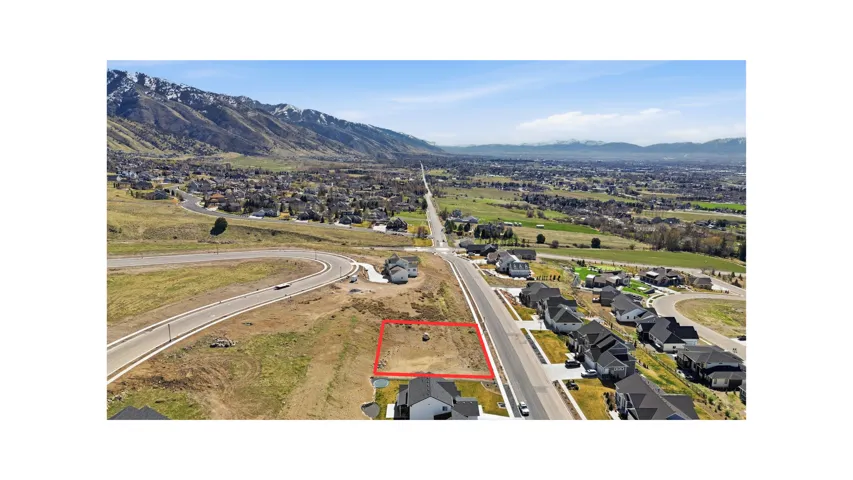 Aerial perspective of suburban area with property boundaries highlighted and a mountainous background