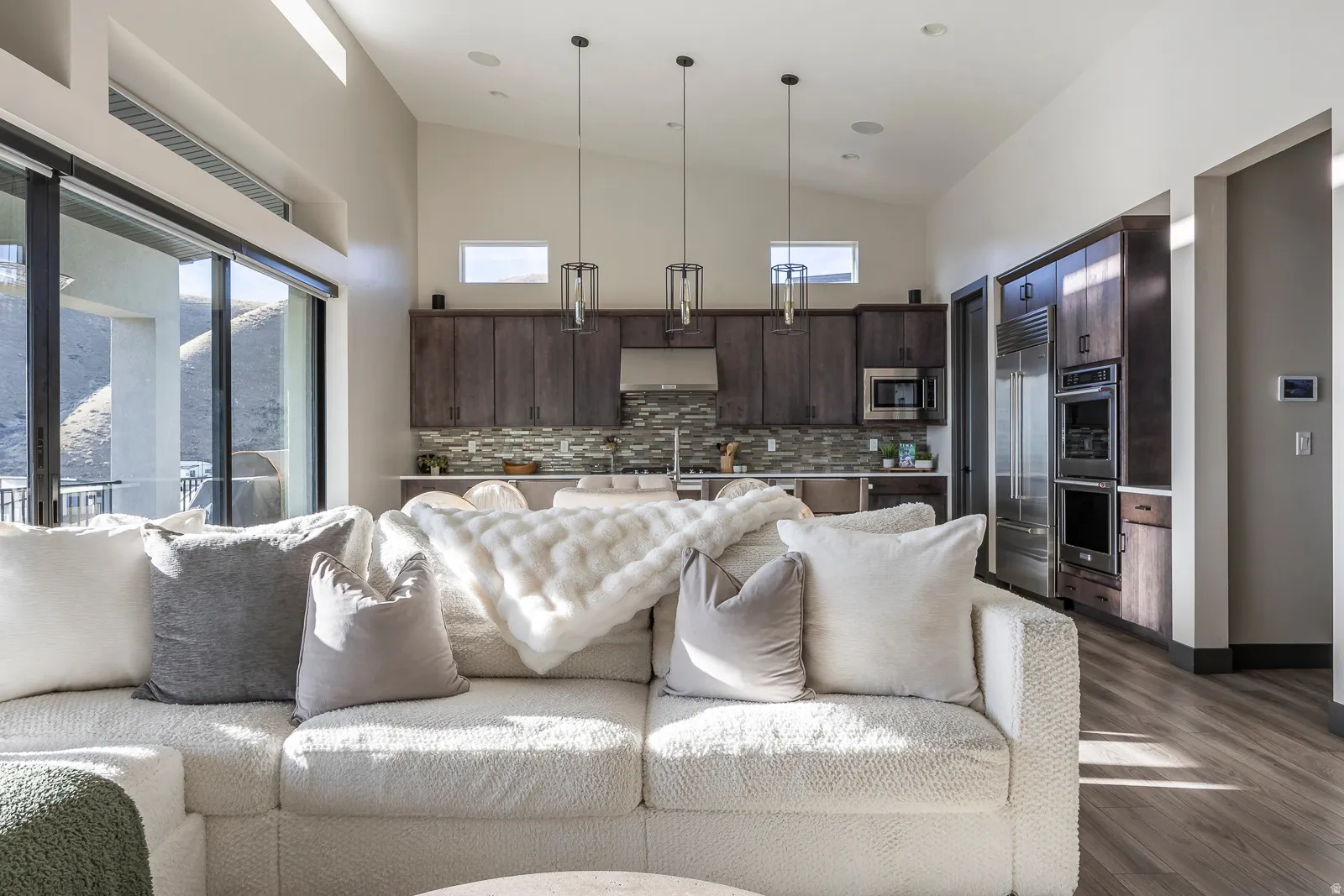 Living room featuring vaulted ceiling and dark wood-style flooring