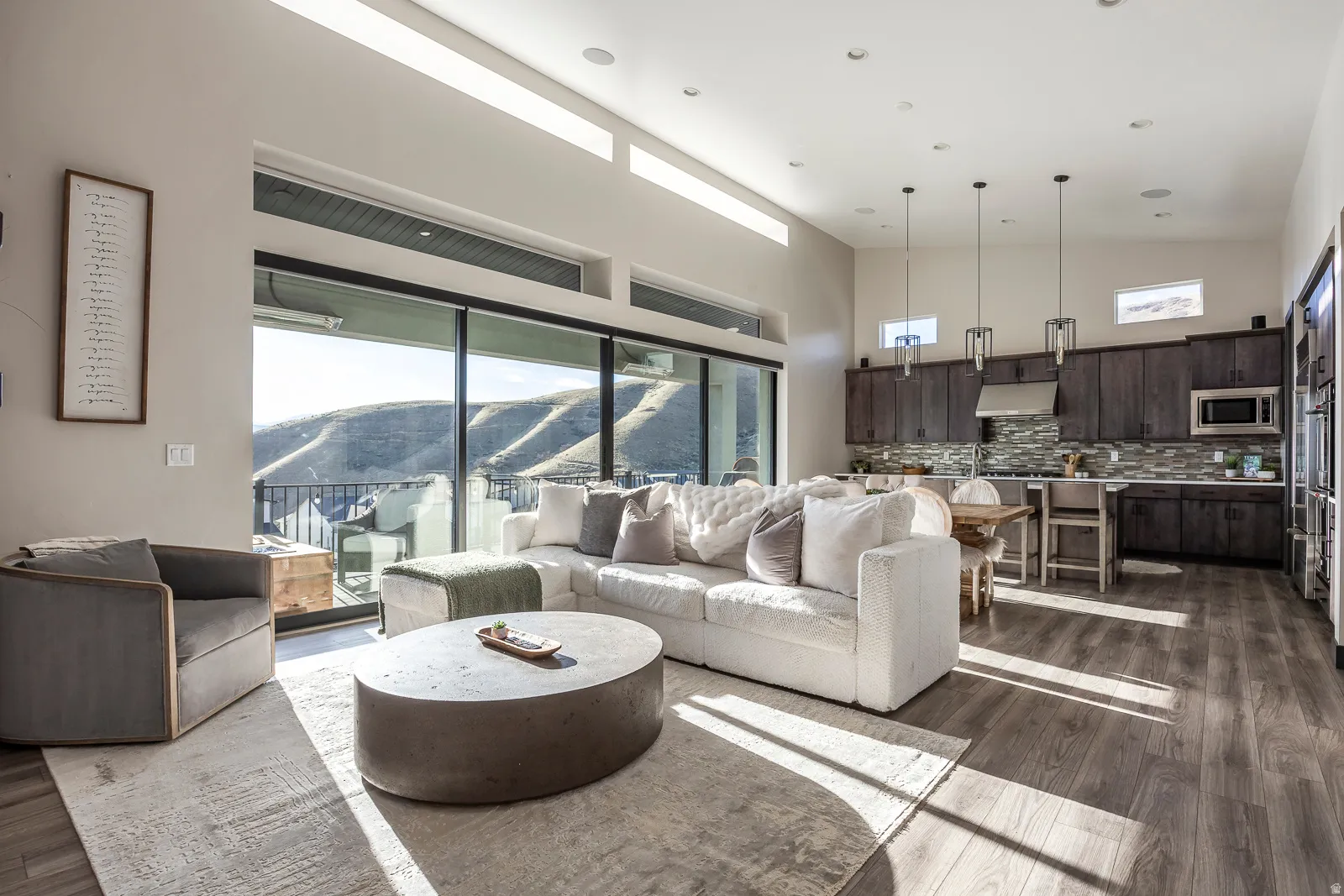 Living area featuring a mountain view, healthy amount of natural light, dark wood-type flooring, vaulted ceiling, and recessed lighting