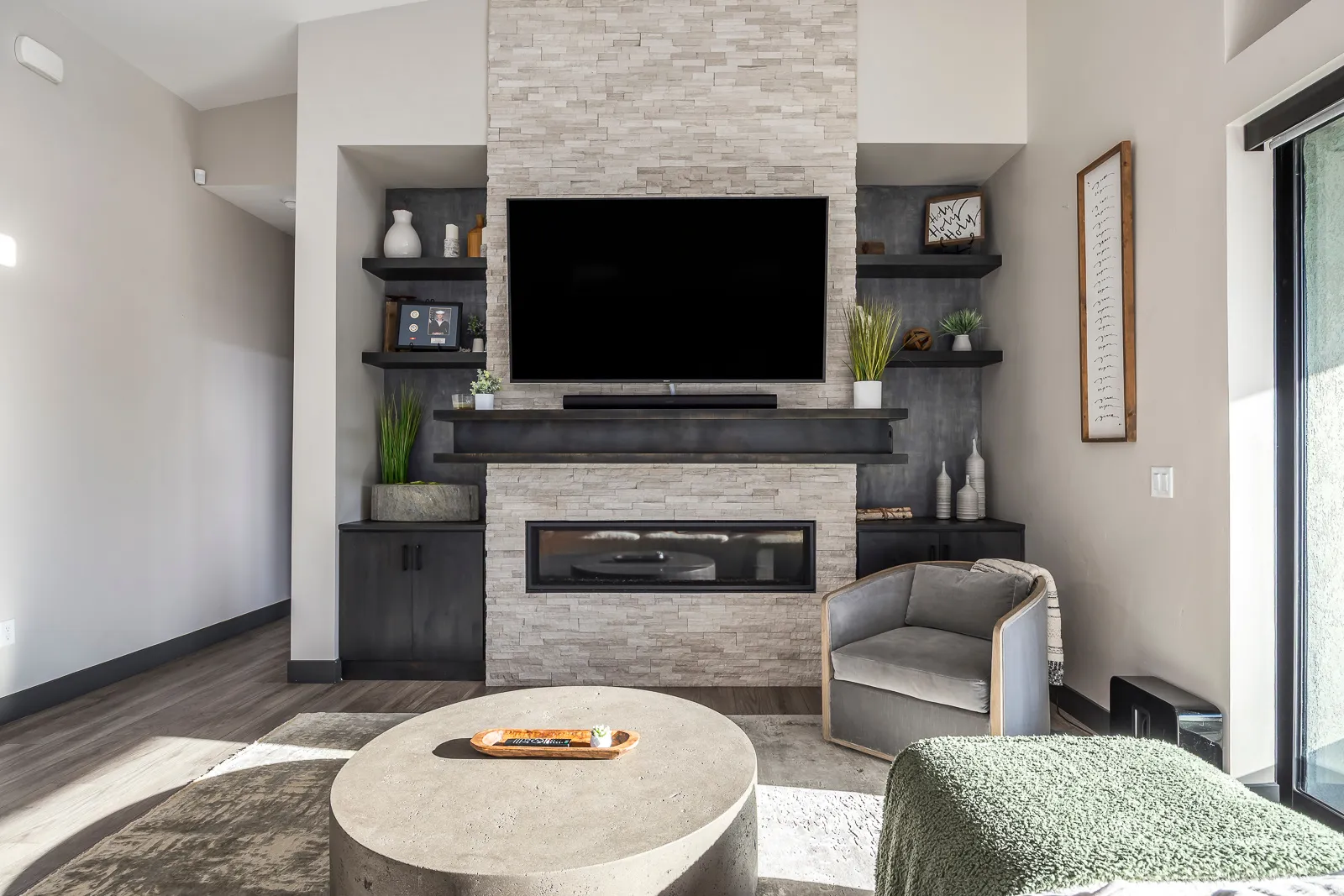 Living room with wood finished floors and a stone fireplace