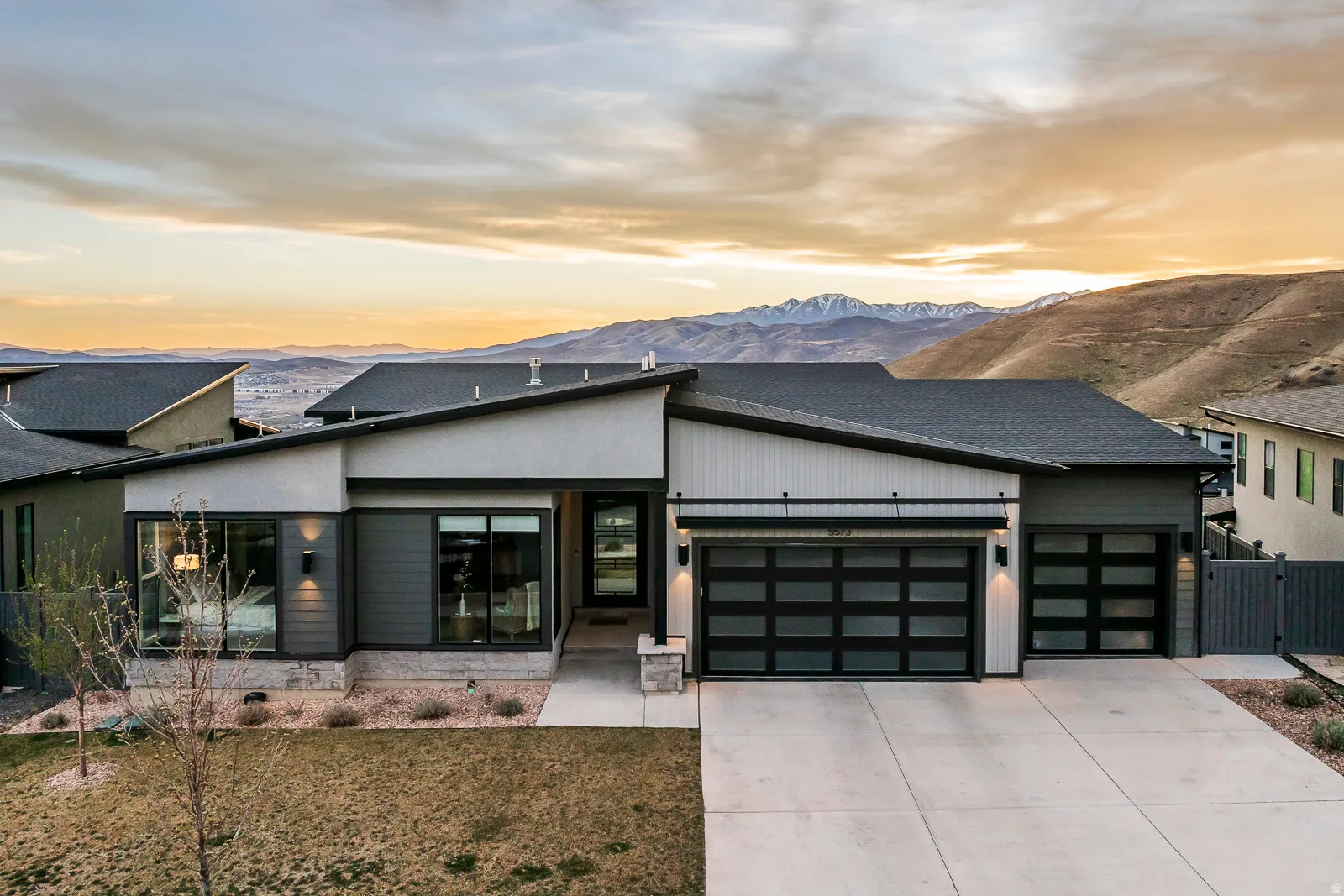 View of front of property with an attached garage, a mountain view, and concrete driveway