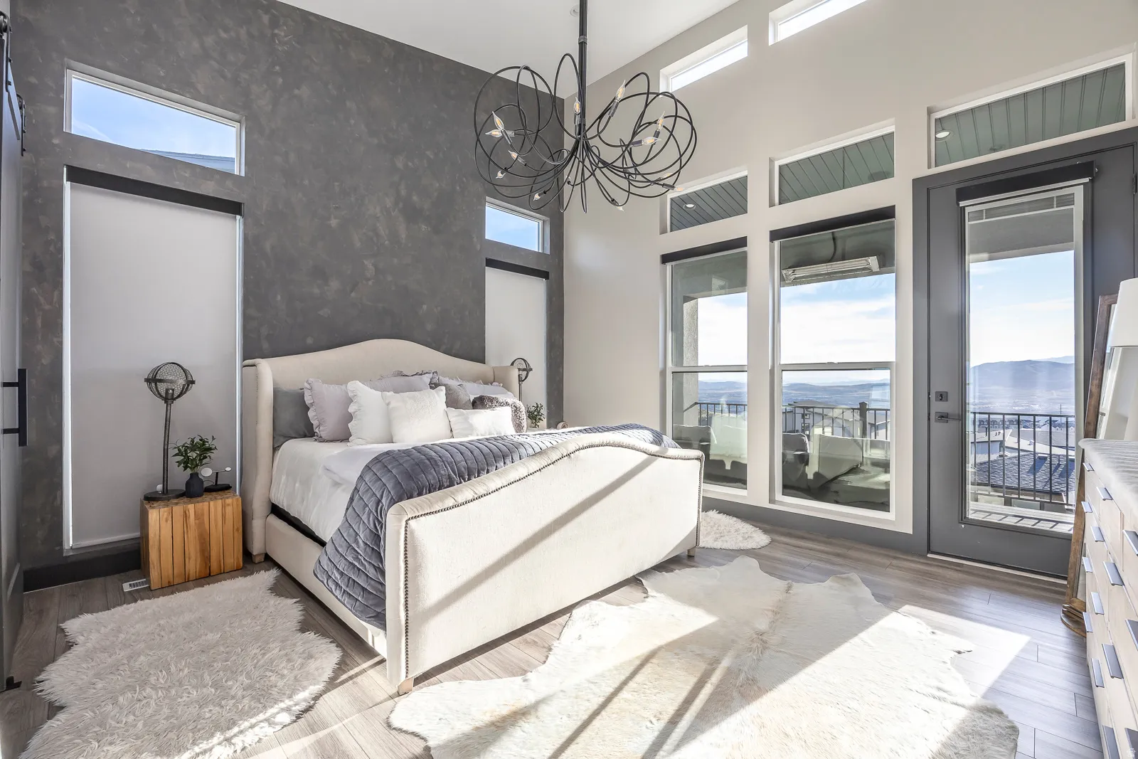 Bedroom with wood finished floors, access to outside, a high ceiling, and hanging lights