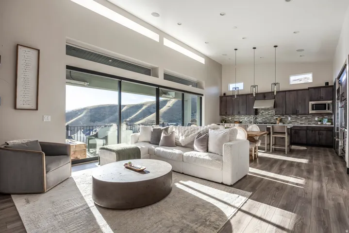 Living area featuring a mountain view, healthy amount of natural light, dark wood-type flooring, vaulted ceiling, and recessed lighting