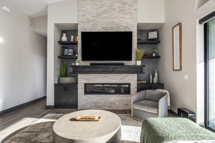 Living room with wood finished floors and a stone fireplace