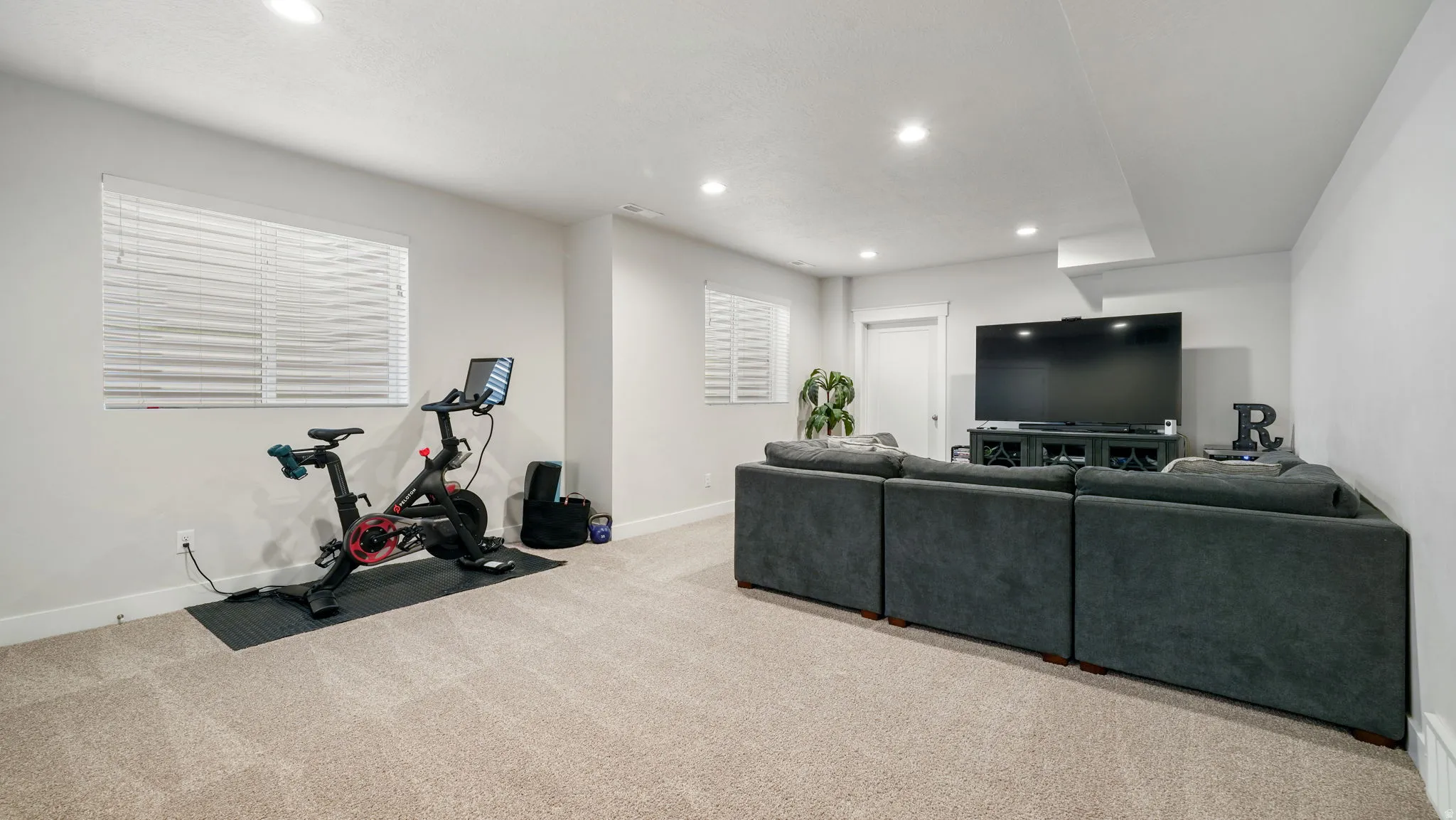 Living area with light colored carpet and recessed lighting