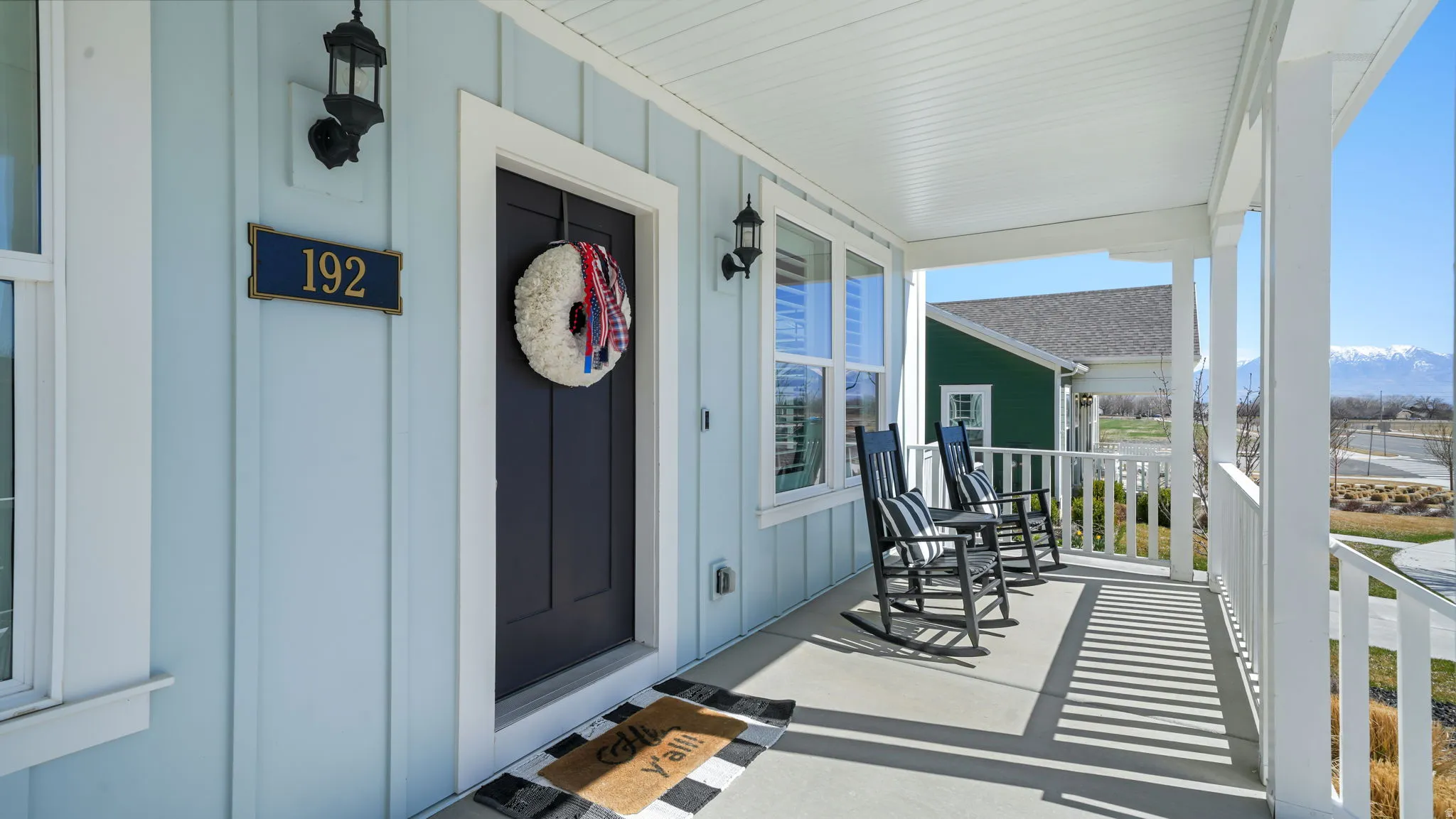Property entrance featuring covered porch and board and batten siding