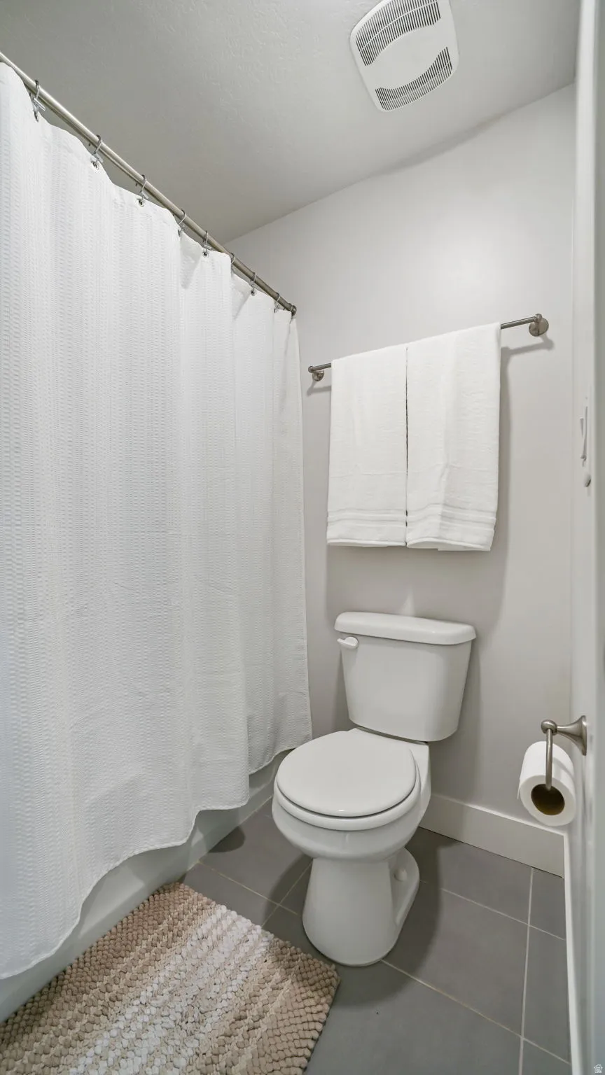 Full bath with dark tile patterned floors