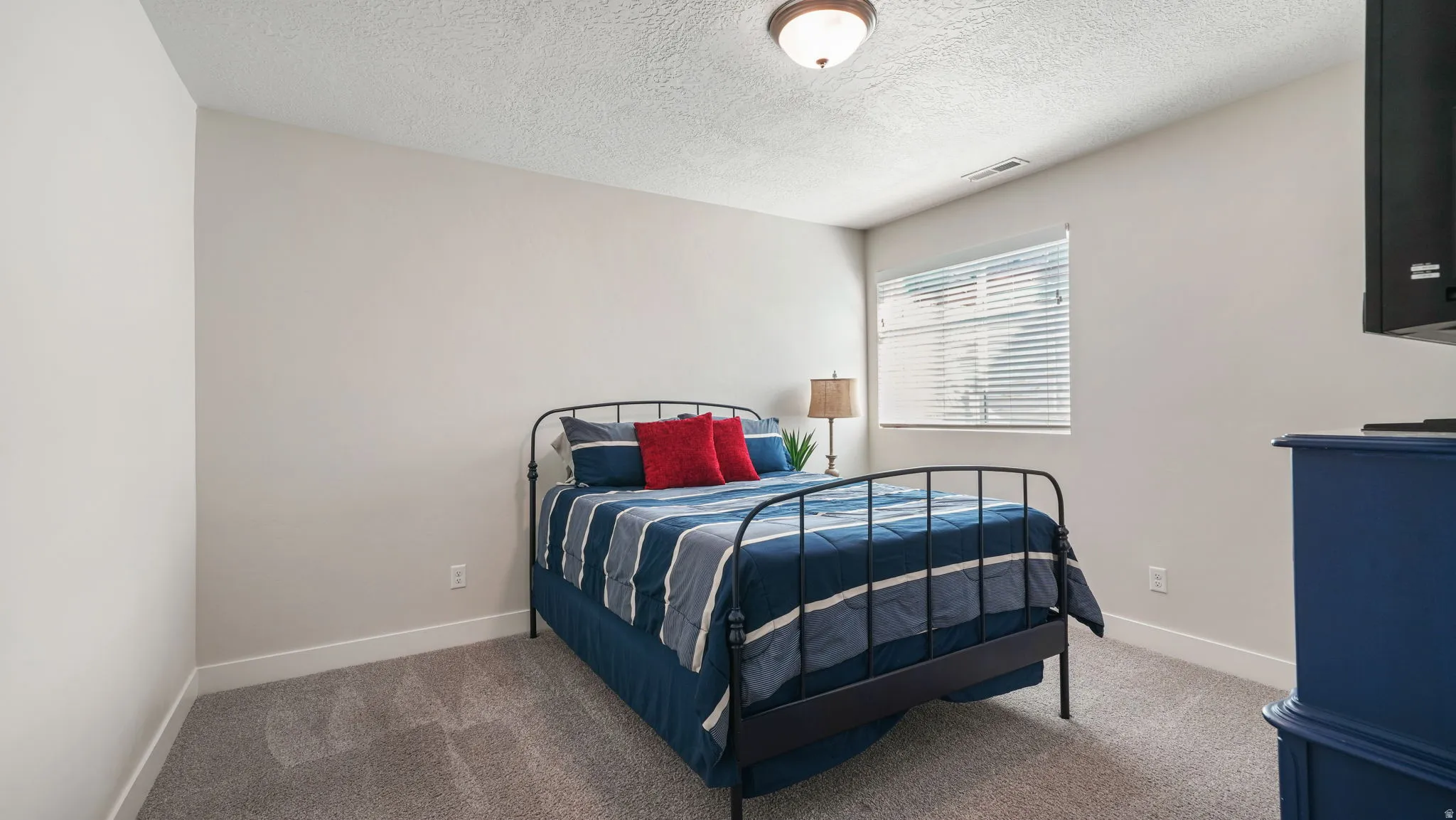 Bedroom featuring carpet flooring and a textured ceiling
