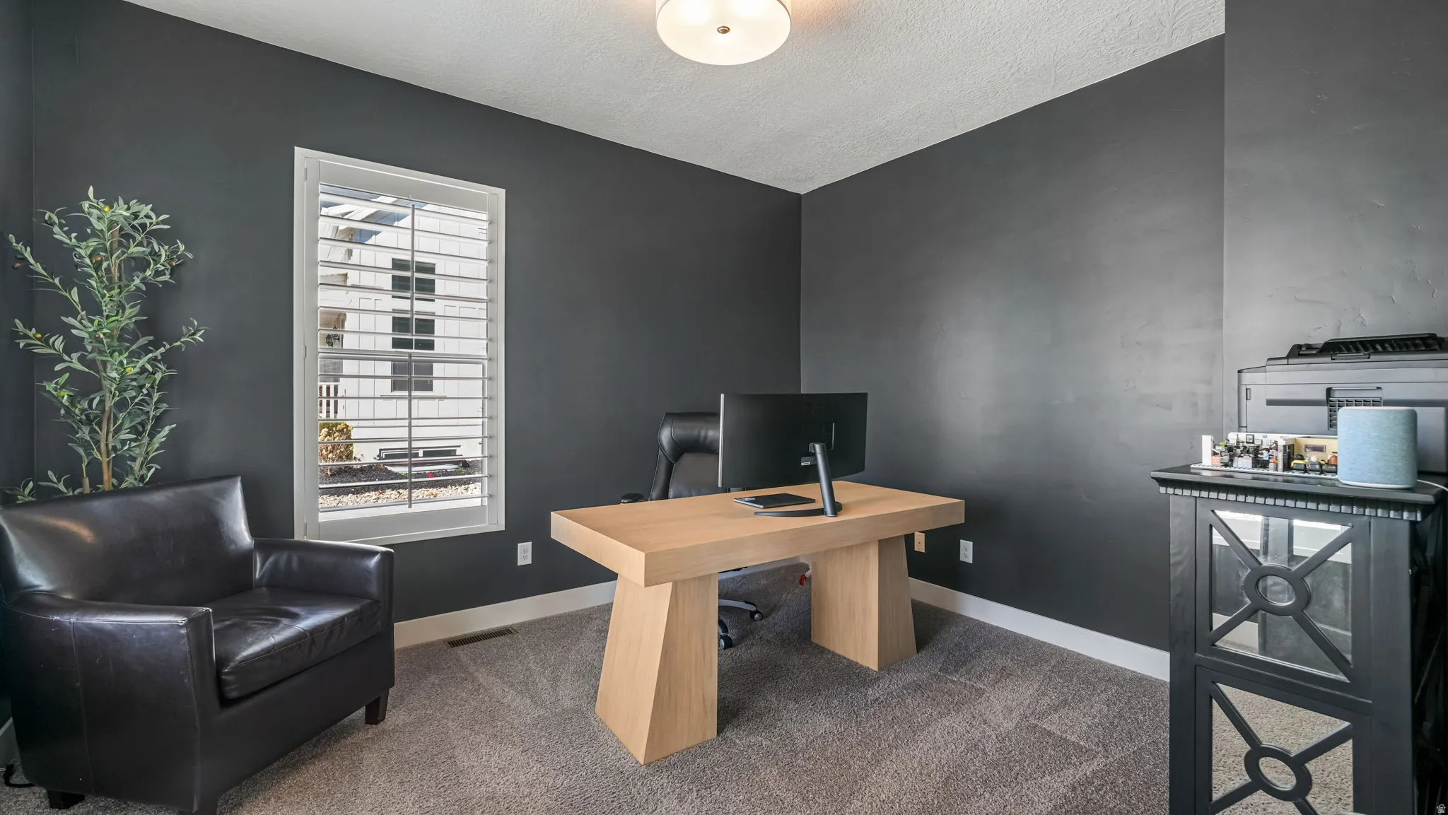 Office featuring carpet floors and a textured ceiling