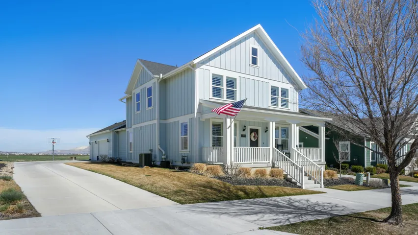 Modern inspired farmhouse with board and batten siding, a porch, driveway, a garage, and a front yard