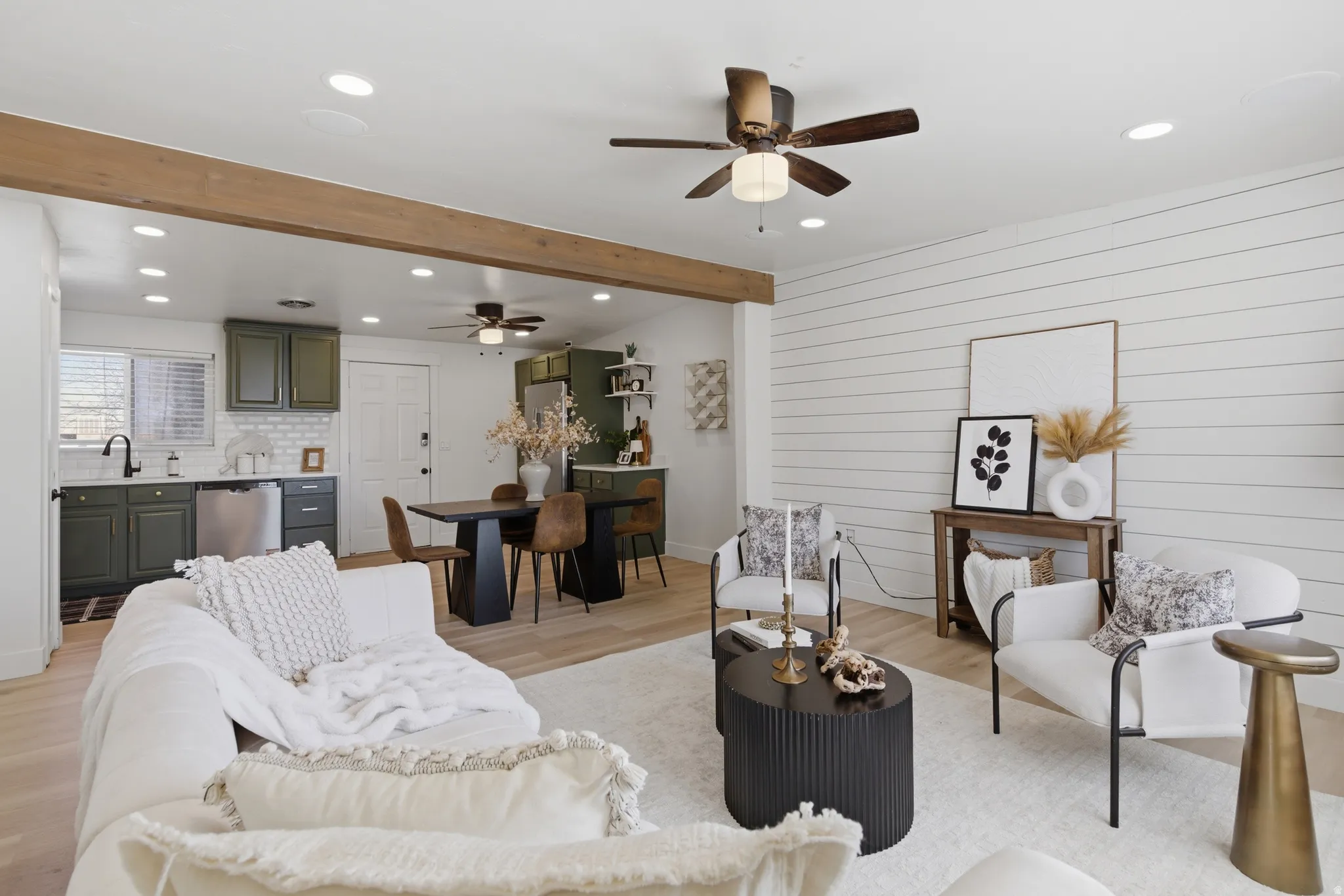 Living room featuring beamed ceiling, recessed lighting, a ceiling fan, light wood finished floors, and wooden walls
