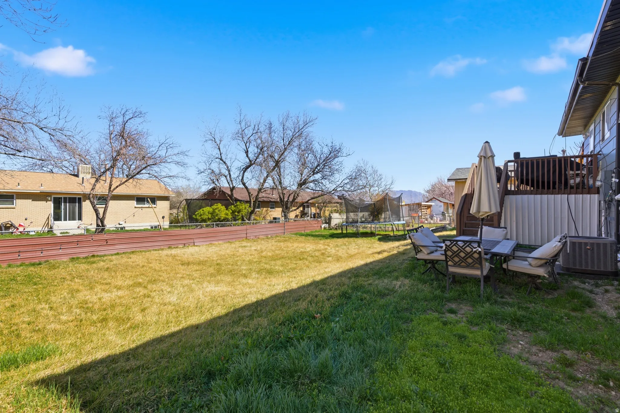 Fenced yard featuring a trampoline and a residential view