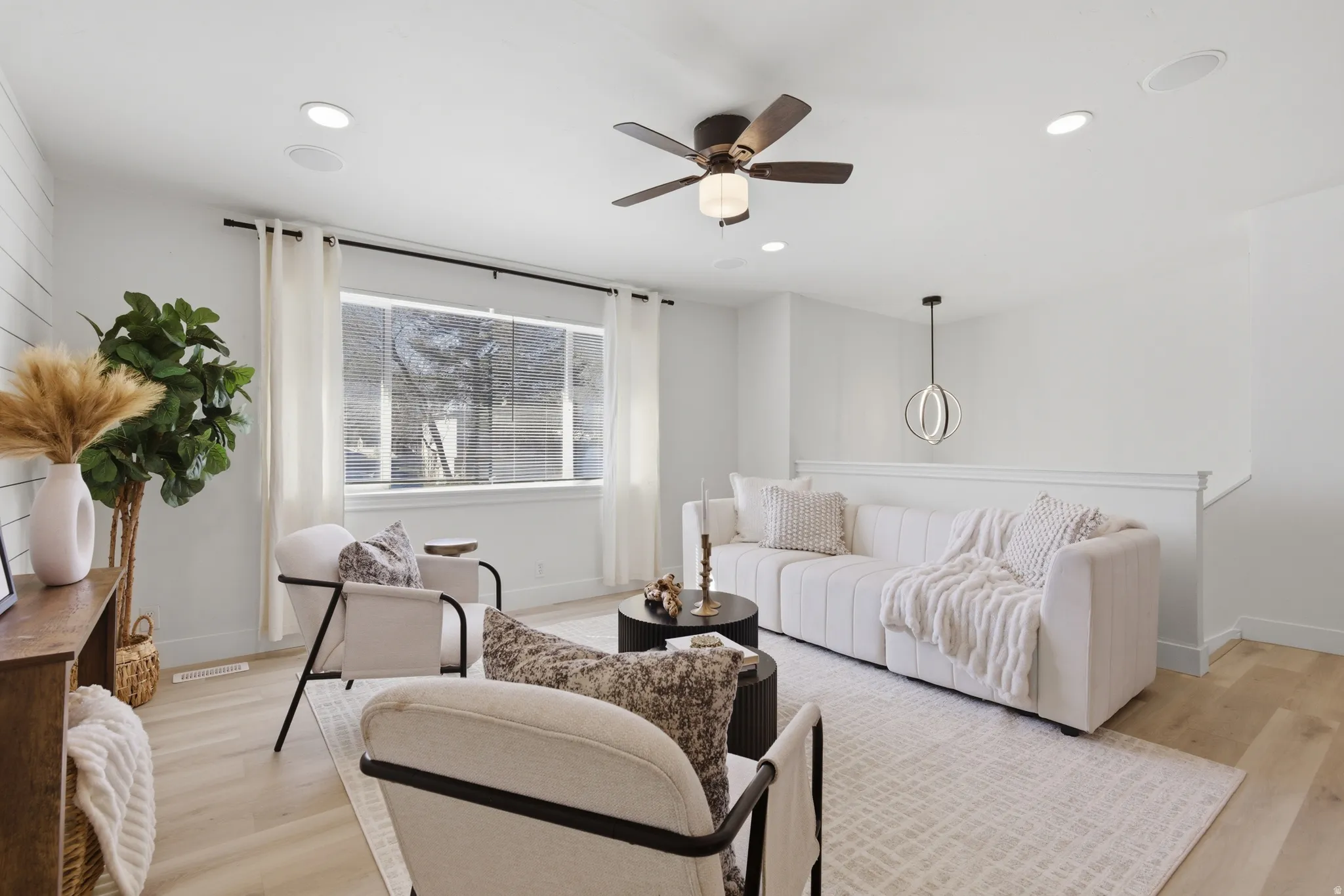 Living area with light wood-style floors, a ceiling fan, and recessed lighting