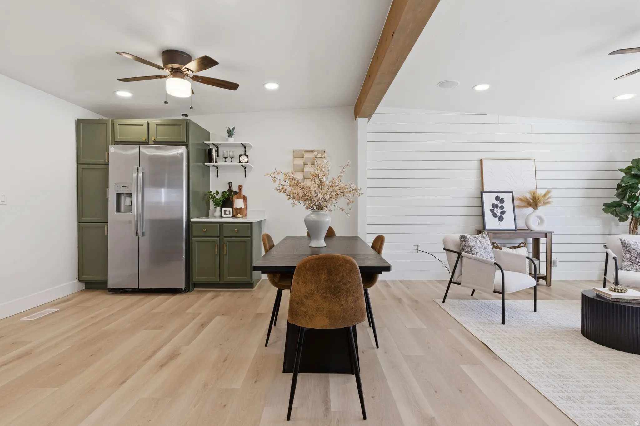 Dining area with a ceiling fan, recessed lighting, light wood-style floors, beam ceiling, and wood walls