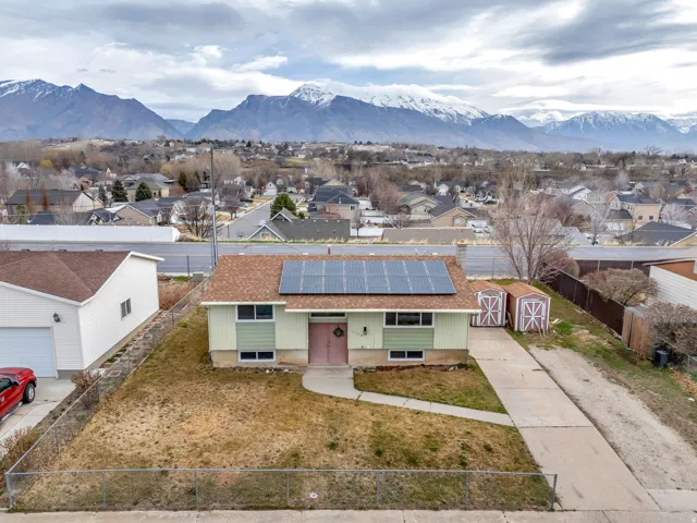 View of front of house with solar panels, a residential view, and a mountain view