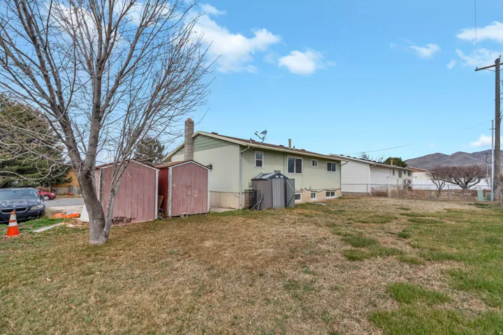 Back of property with a storage unit and a chimney