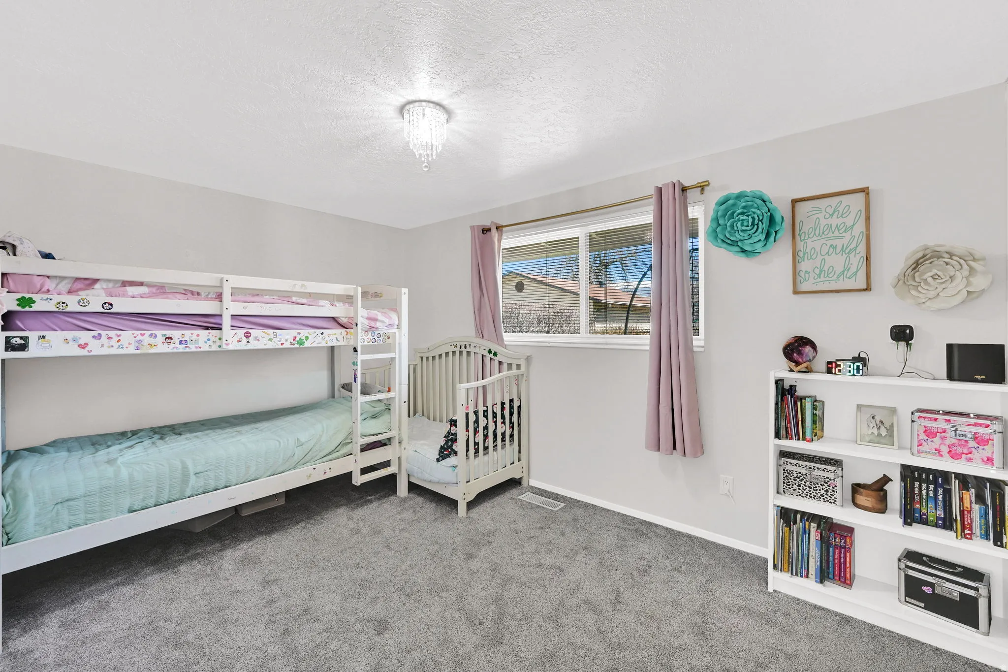 Bedroom featuring light colored carpet and a textured ceiling