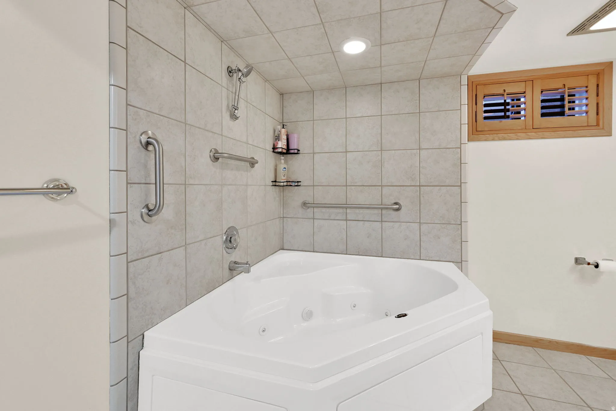 Bathroom featuring light tile patterned floors, a combined bath / shower with jetted tub, and recessed lighting