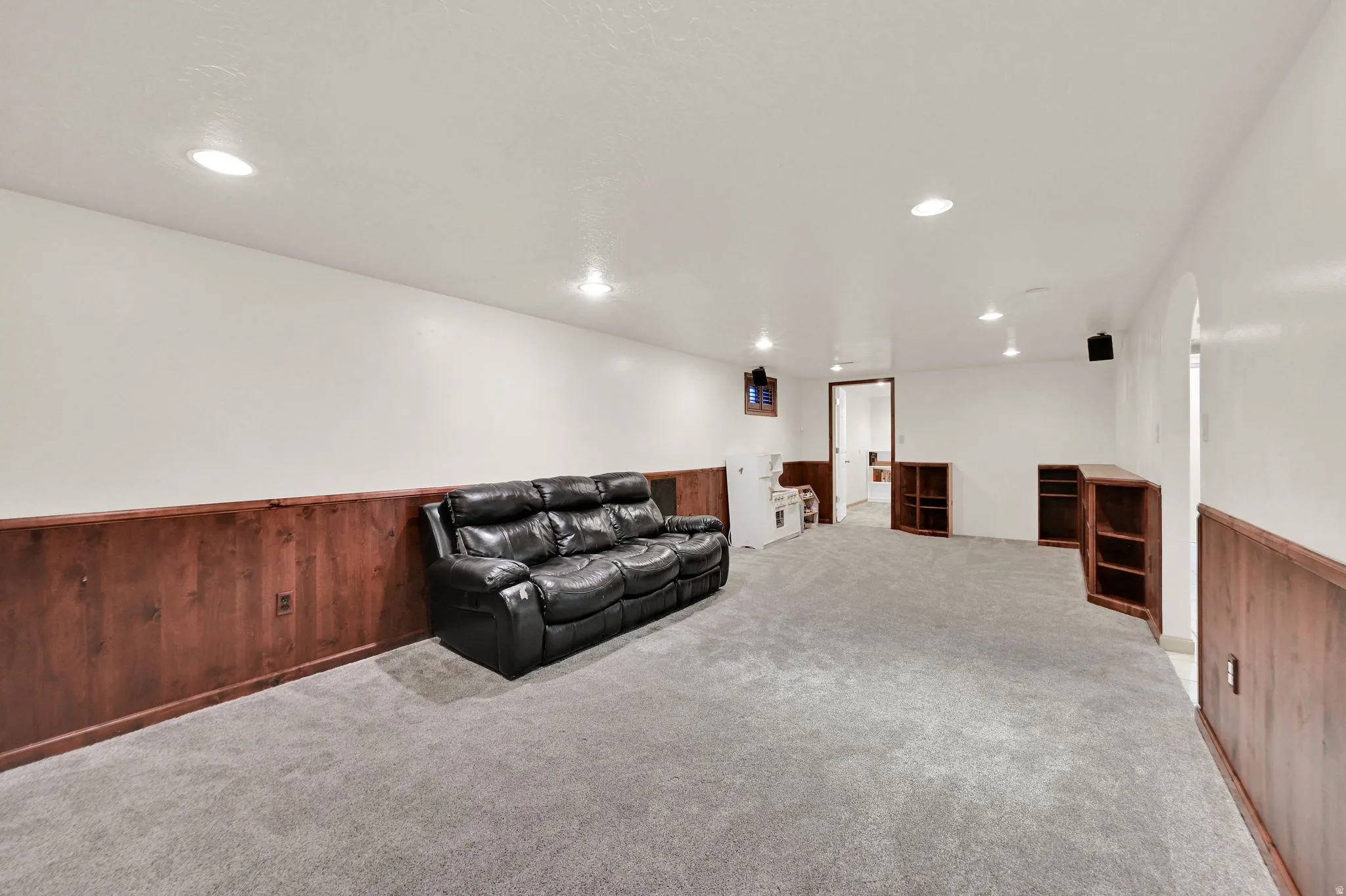 Living area featuring wooden walls, a wainscoted wall, light carpet, and recessed lighting