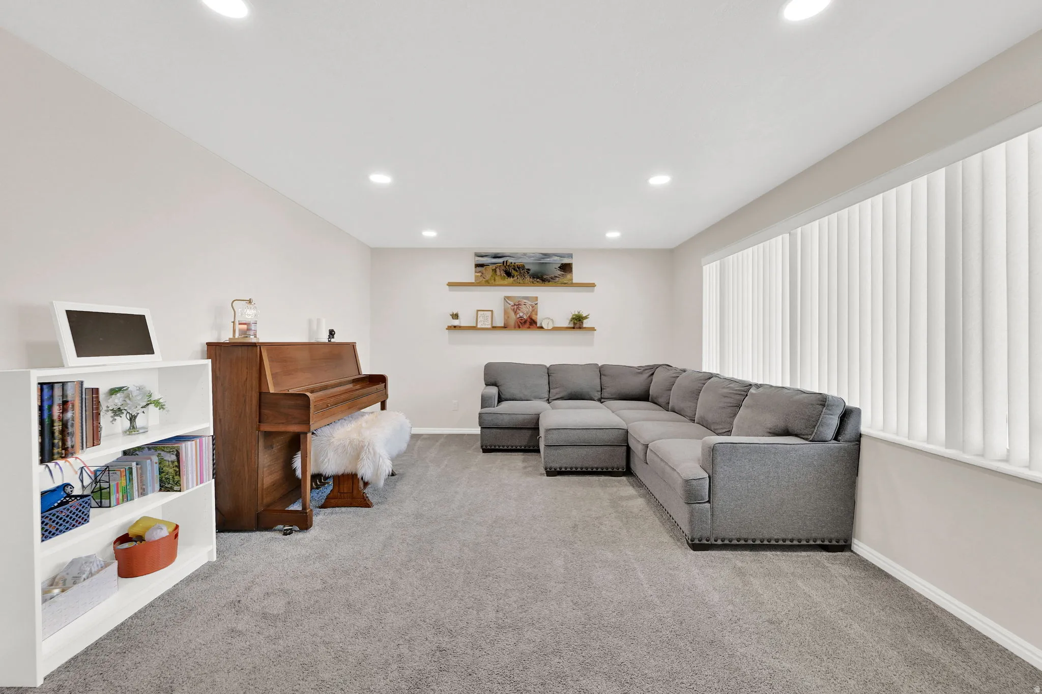Living area with light carpet and recessed lighting