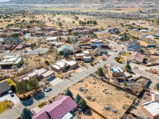 Aerial view of property and surrounding area with nearby suburban area and a mountainous background