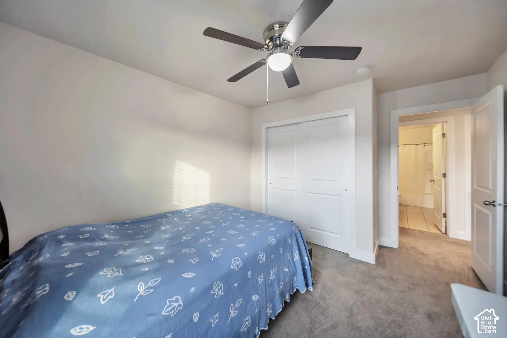 Bedroom featuring carpet floors, a closet, and a ceiling fan