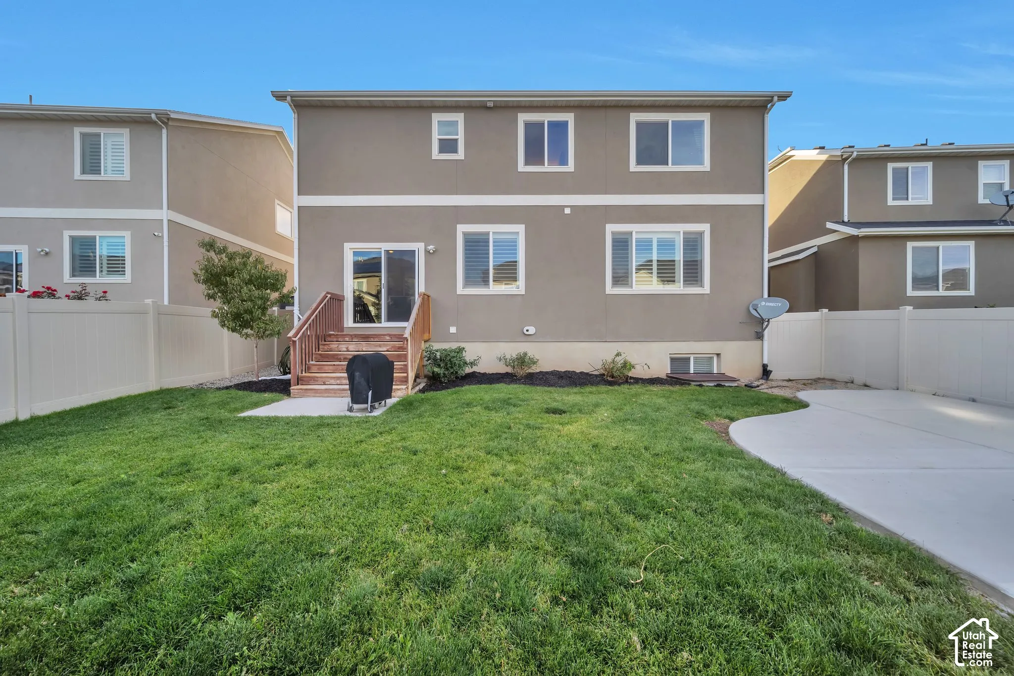 Rear view of house with a fenced backyard and a large patio