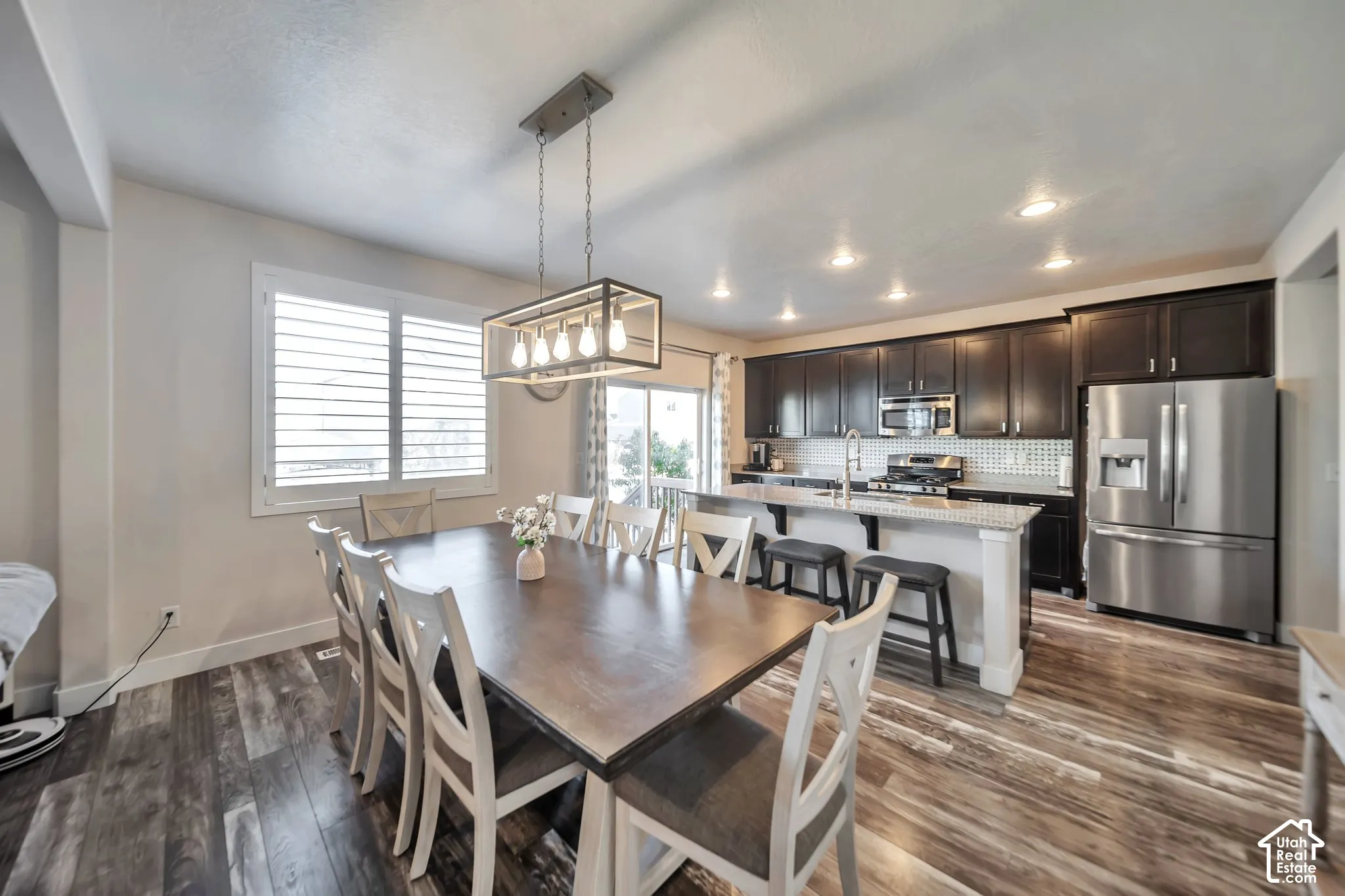 Dining area with wood-style floors and recessed lighting