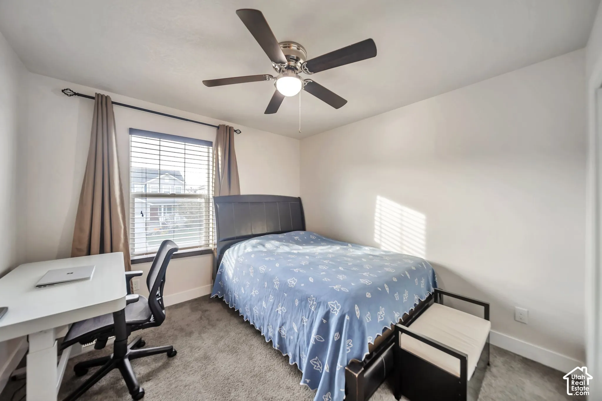 Carpeted bedroom with a ceiling fan