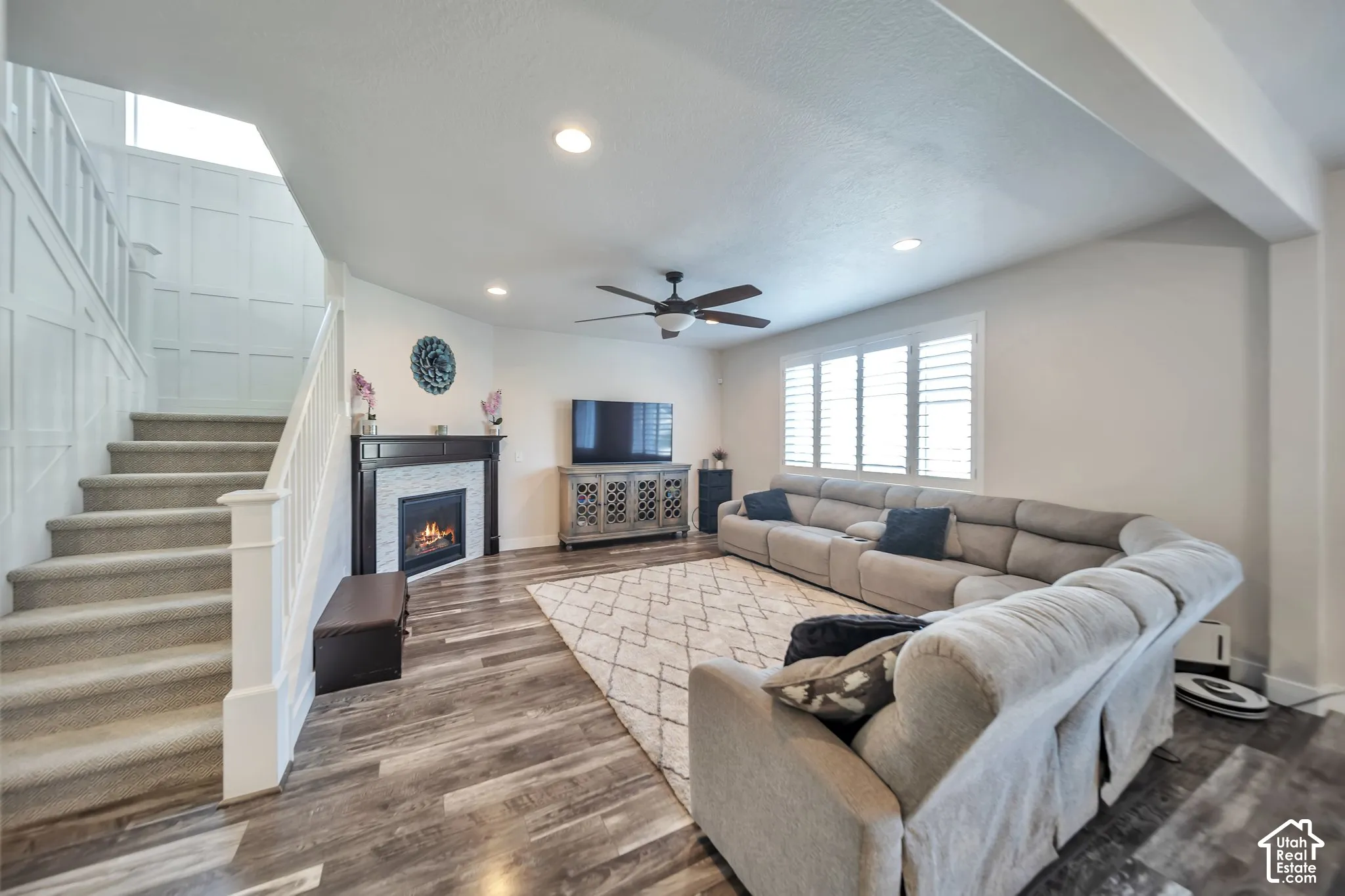 Family  room area with wood finished floors, a fireplace, ceiling fan, and recessed lighting