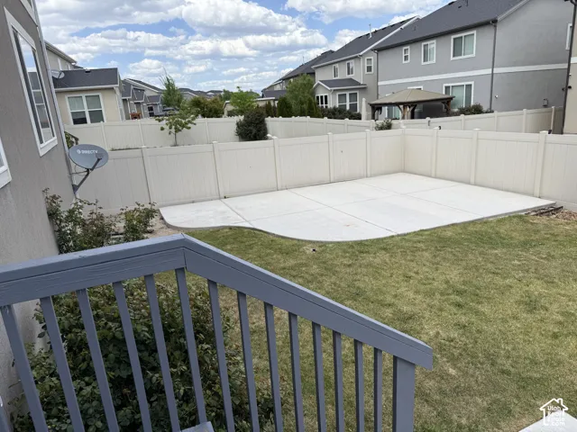 Fenced backyard featuring a concrete patio and a lawn area