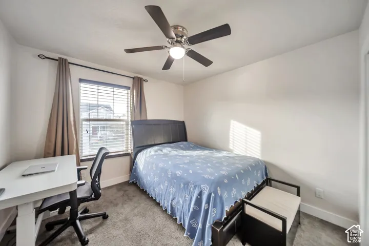 Carpeted bedroom with a ceiling fan