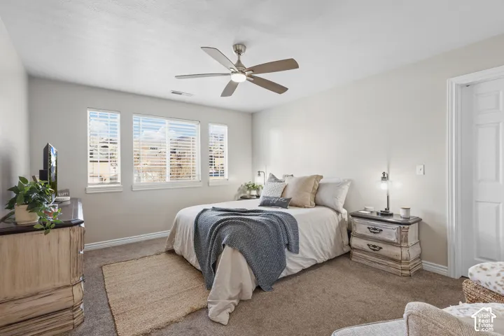 Carpeted bedroom featuring baseboards and a ceiling fan