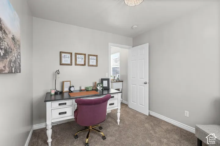 Office featuring dark colored carpet and baseboards