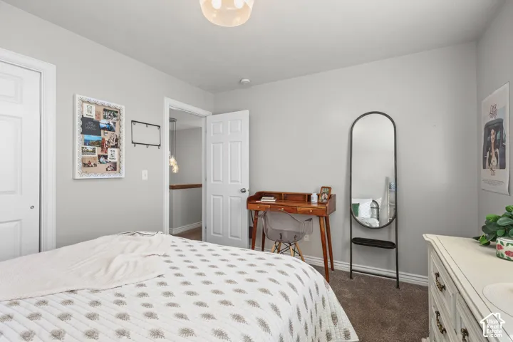Bedroom with baseboards and dark carpet