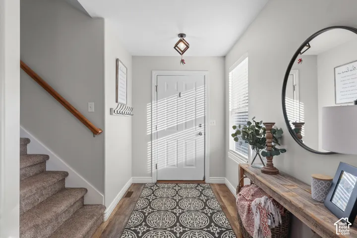 Foyer entrance with stairway and dark wood-type flooring