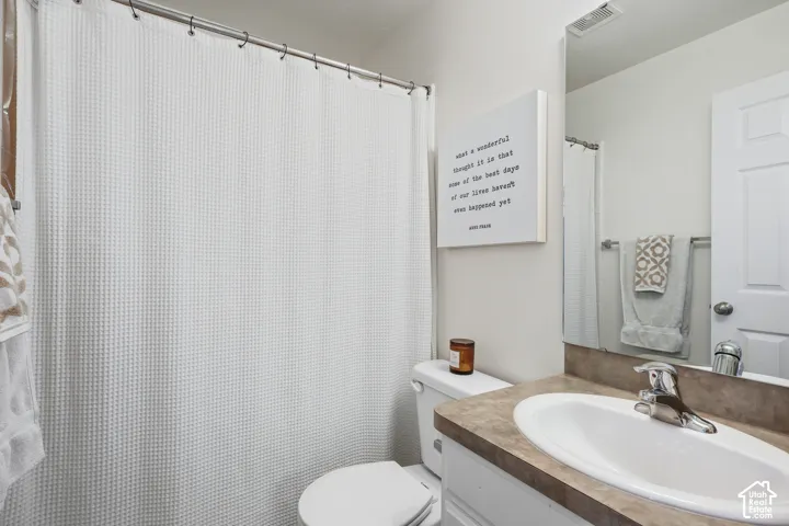 Full bath featuring vanity and curtained shower