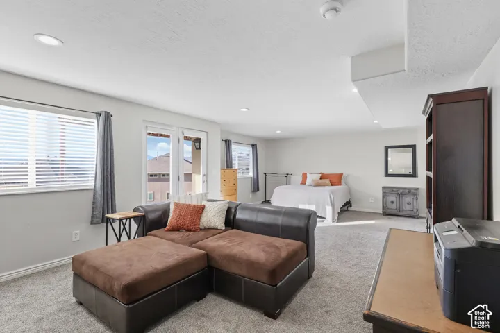 Carpeted bedroom with a textured ceiling and recessed lighting