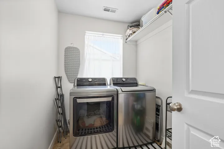 Laundry room with washer and dryer and baseboards