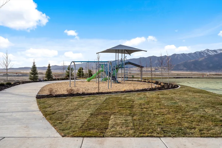 Community playground with a mountain view and a yard