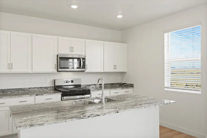 *DISCLAIMER* Interior package and colors may vary.  Kitchen featuring white cabinets, light stone countertops, stainless steel appliances, and recessed lighting