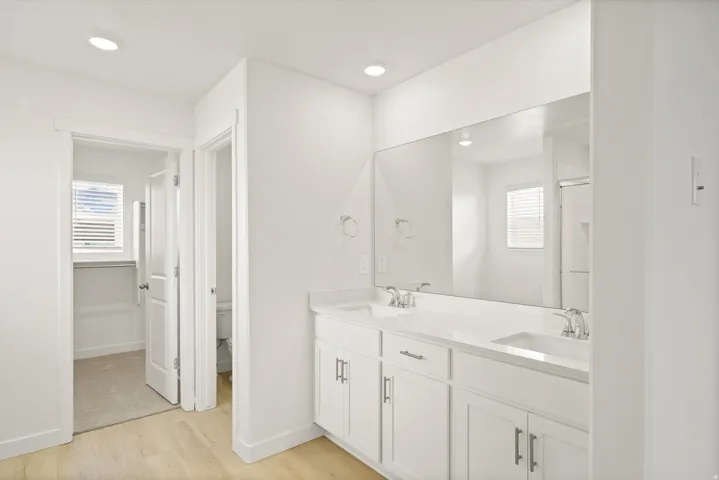*DISCLAIMER* Interior package and colors may vary.  Full bathroom featuring double vanity, light wood finished floors, recessed lighting, and a shower stall
