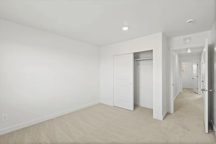 *DISCLAIMER* Interior package and colors may vary.  Unfurnished bedroom with light carpet and a closet